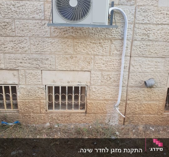 יחידת מיזוג אוויר מותקנת על קיר אבן חיצוני